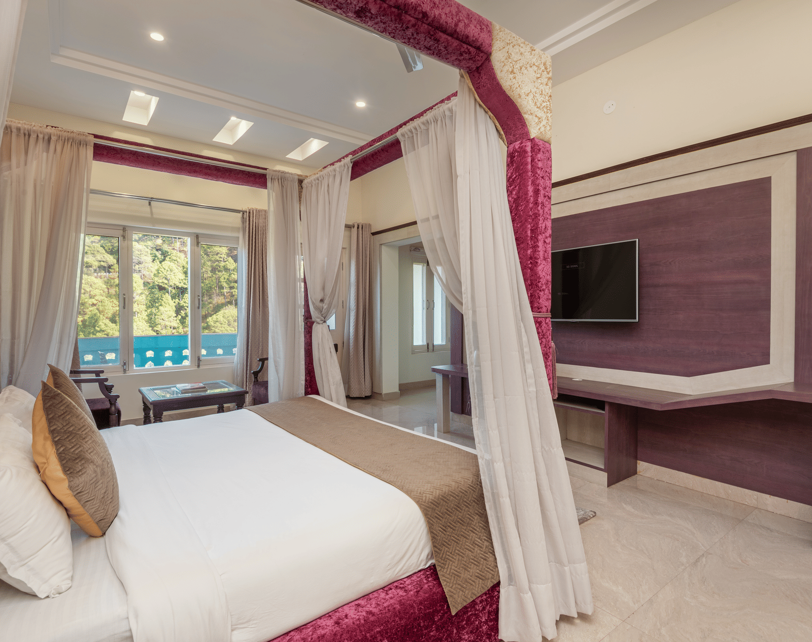 Luxurious bedroom at DLS Tehri Club Resort with a four-poster bed and elegant decor.